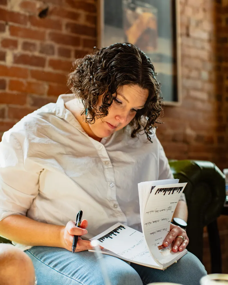 A tastemaker writing her scores on a Marquee tasting sheet